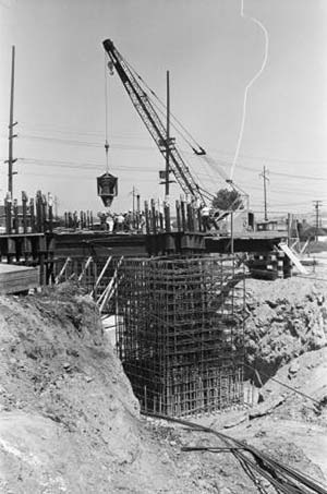 Workers using concrete bucket to pour Space Needle foundation - circa May 1961